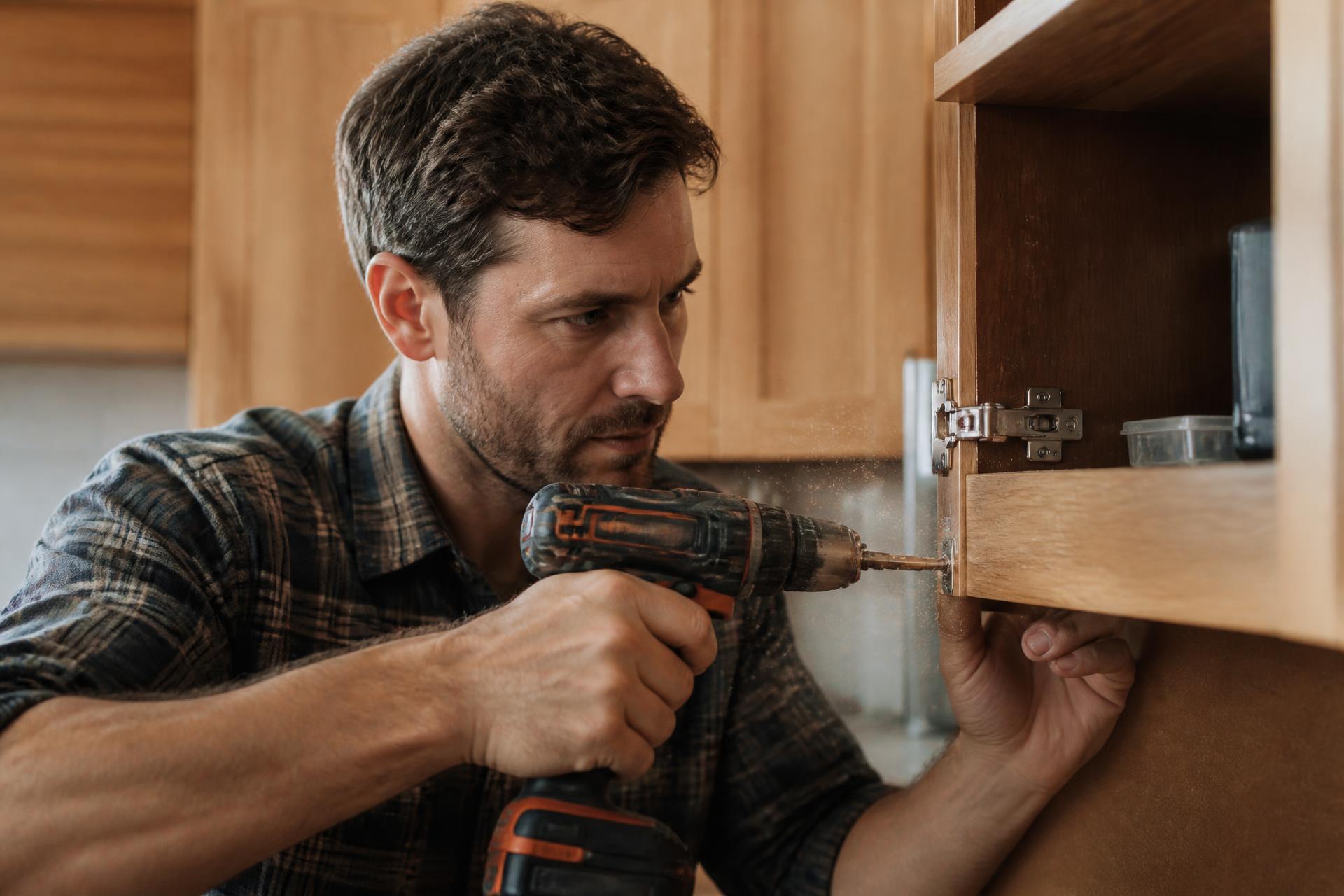 Handyman installing a fixture with a power drill